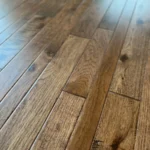 Angled view of hand-scraped brown wood floor planks