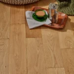 Close-up of light oak floor with coffee tray and pouf.
