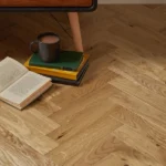 Close-up of oak herringbone flooring by furniture