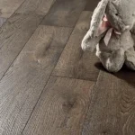 Close-up of rustic dark wood floor with stuffed bunny
