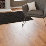 Detail of oak flooring with a modern chair and rug