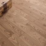 High-angle view of oak wood flooring with a woven box