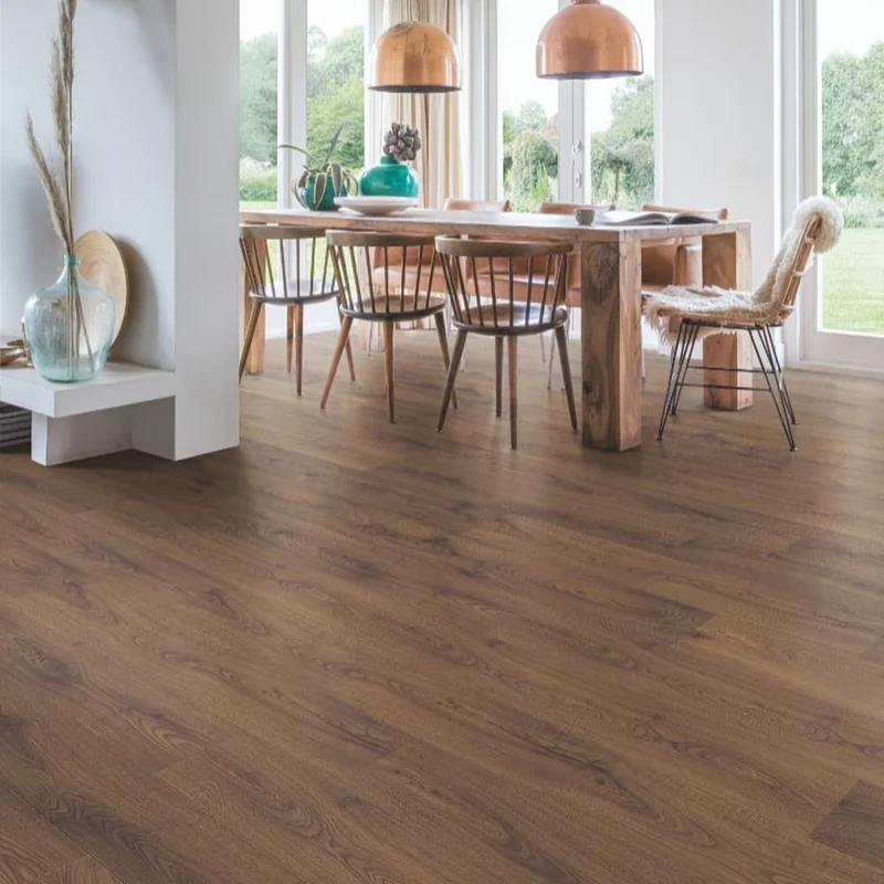 Medium-brown oak wood flooring in a bright dining room with a rustic wooden table.