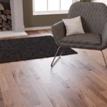 Modern grey armchair on oak wood floors.
