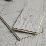 Two light gray wood flooring samples stacked