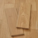 Two sample planks of light oak flooring on a matching floor.