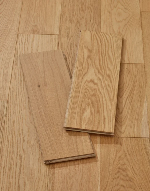 Two sample planks of light oak flooring on a matching floor.