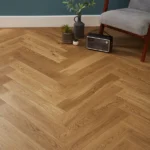 Wide view of oak herringbone flooring in a room.