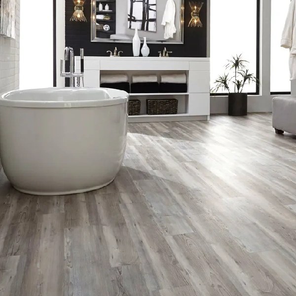 Bathroom with a white freestanding tub and a gray wood-look floor.